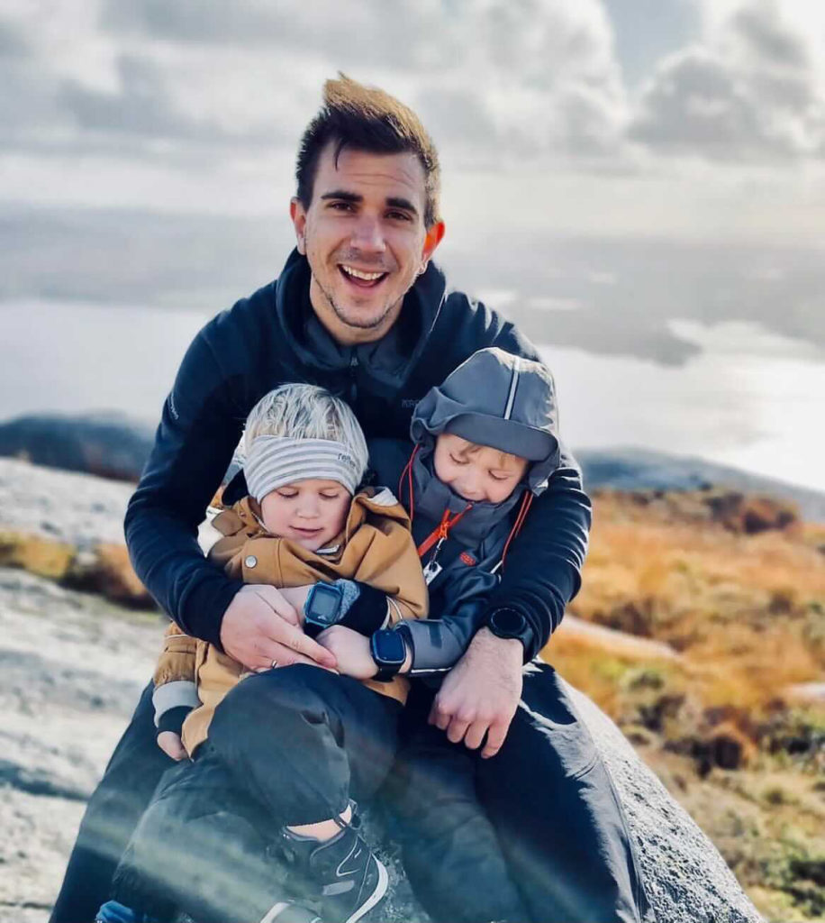 pappa sitter på en sten med sina två barn